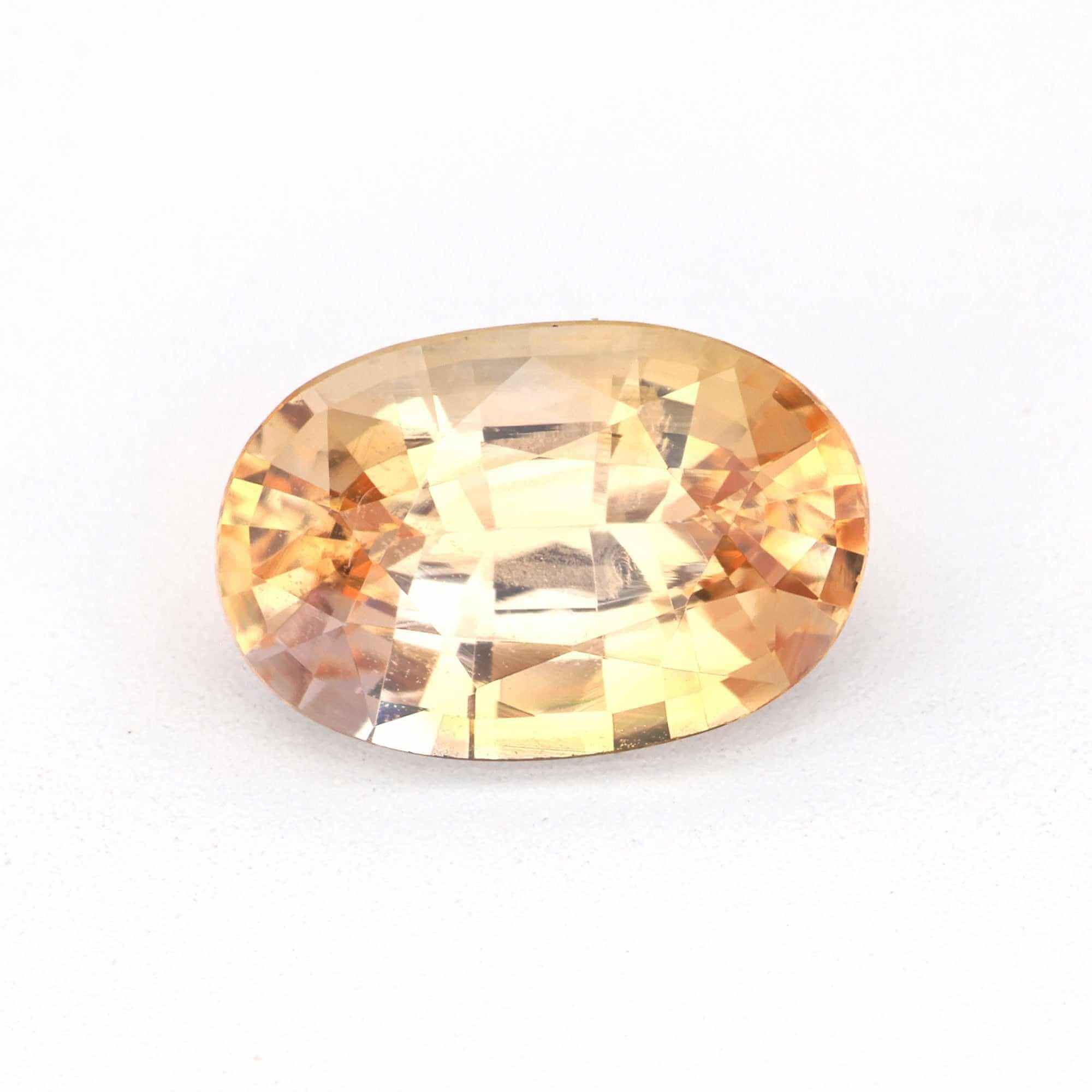 Close-up of a soft pink-orange peach sapphire gemstone showcasing its delicate hues