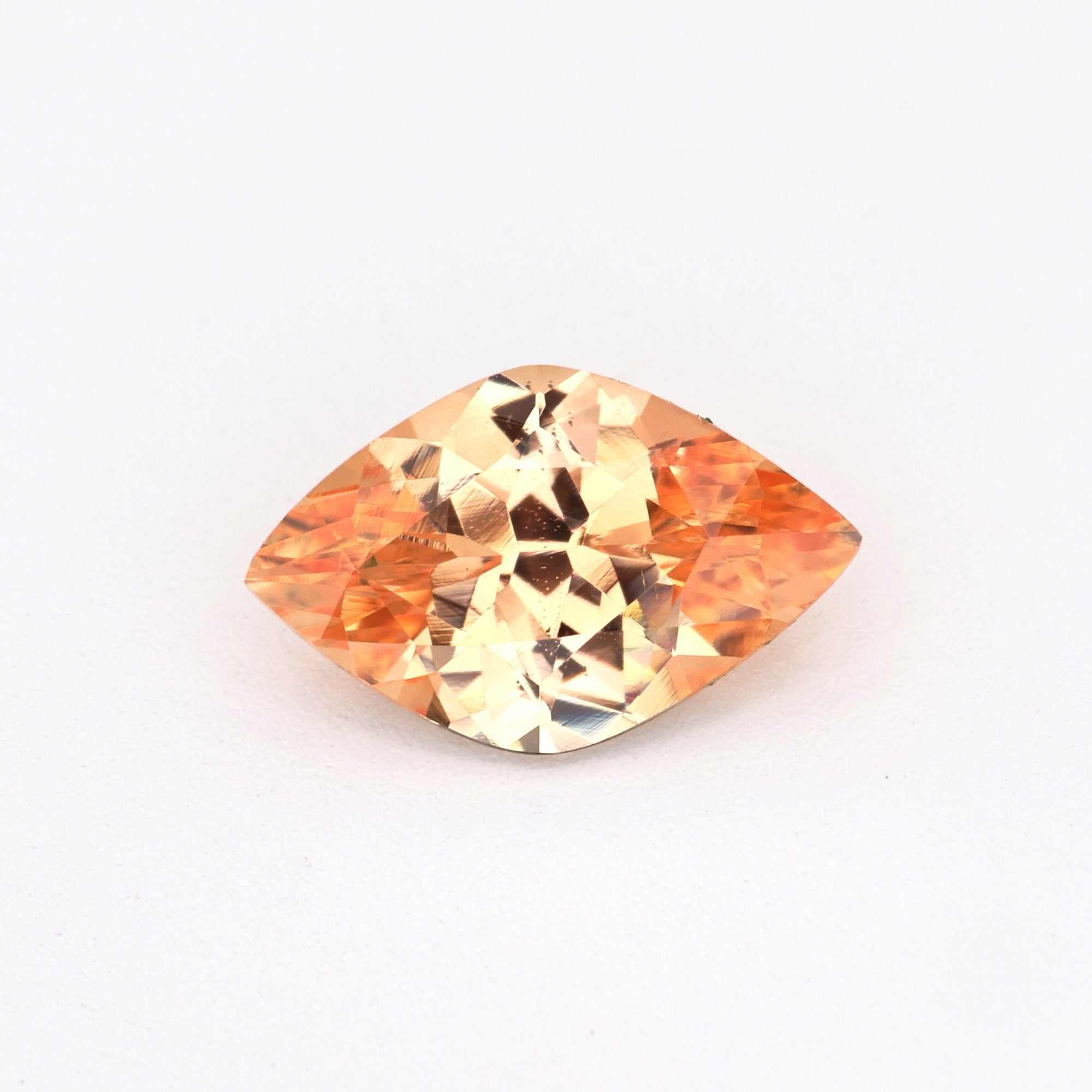 Close-up of a 0.79 ct unheated peach sapphire gemstone with brilliant soft peach hue and excellent clarity