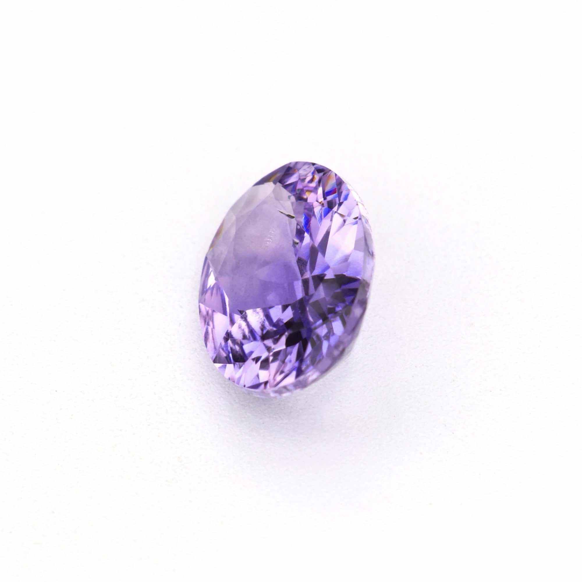 0.83 ct Oval Violet Sapphire displayed on a white background, showcasing its lavender-violet hue and faceted cut.