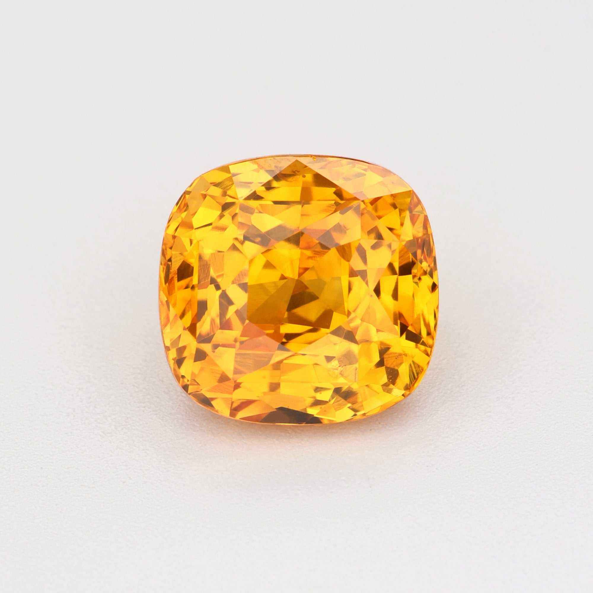 Close-up of a vibrant orange sapphire gemstone showcasing its fiery, rare beauty and brilliance.