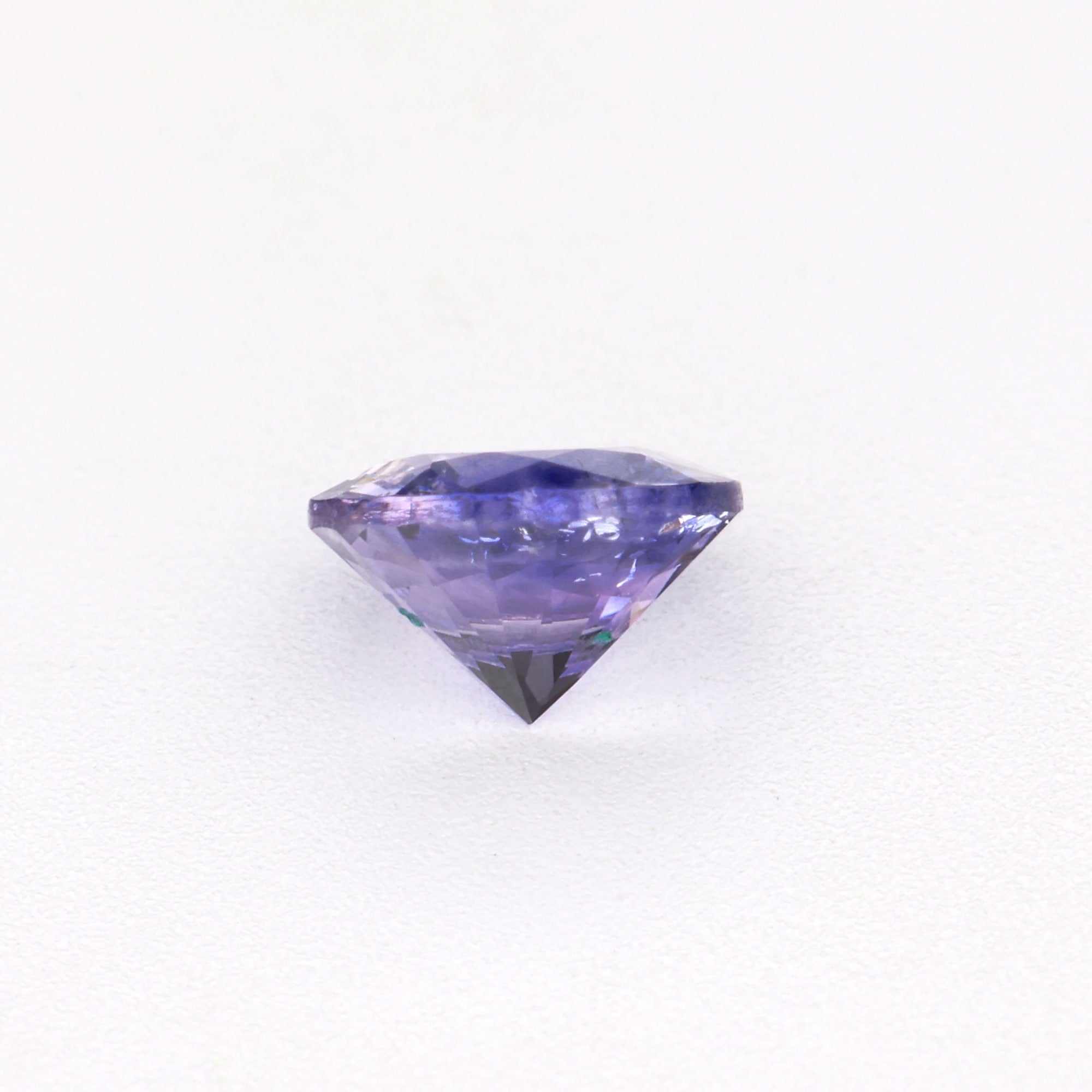 Close-up of a 0.44 ct untreated violet sapphire gemstone with rich purple color and excellent clarity