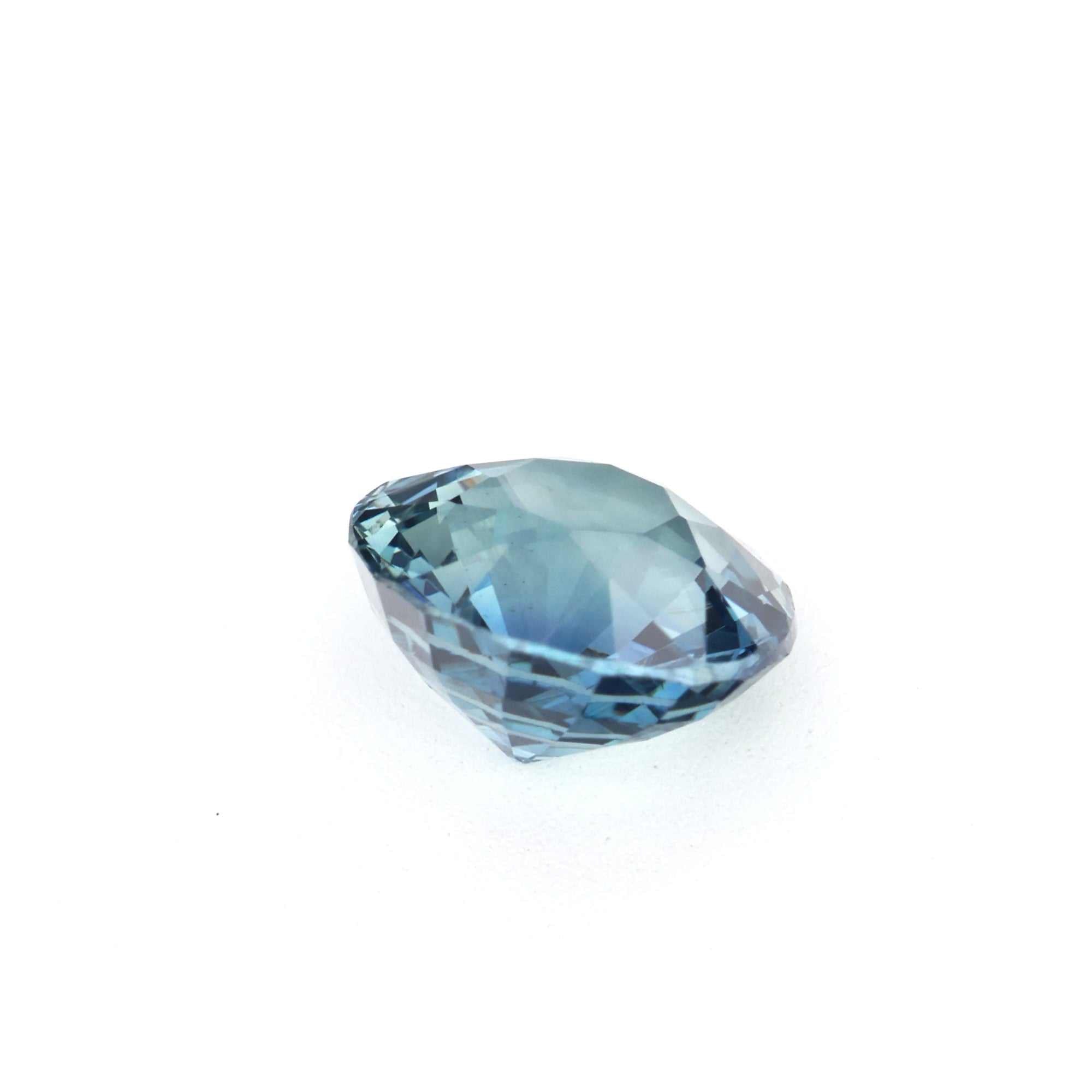 Close-up of a 1.08 carat unheated teal sapphire gemstone showcasing vibrant blue-green hues and brilliant cut