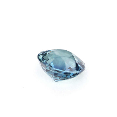 Close-up of a 1.08 carat unheated teal sapphire gemstone showcasing vibrant blue-green hues and brilliant cut