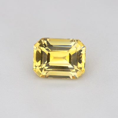 1.17 ct Emerald-Cut Ceylon Yellow Sapphire displayed on a neutral background, showcasing its vibrant golden hue.