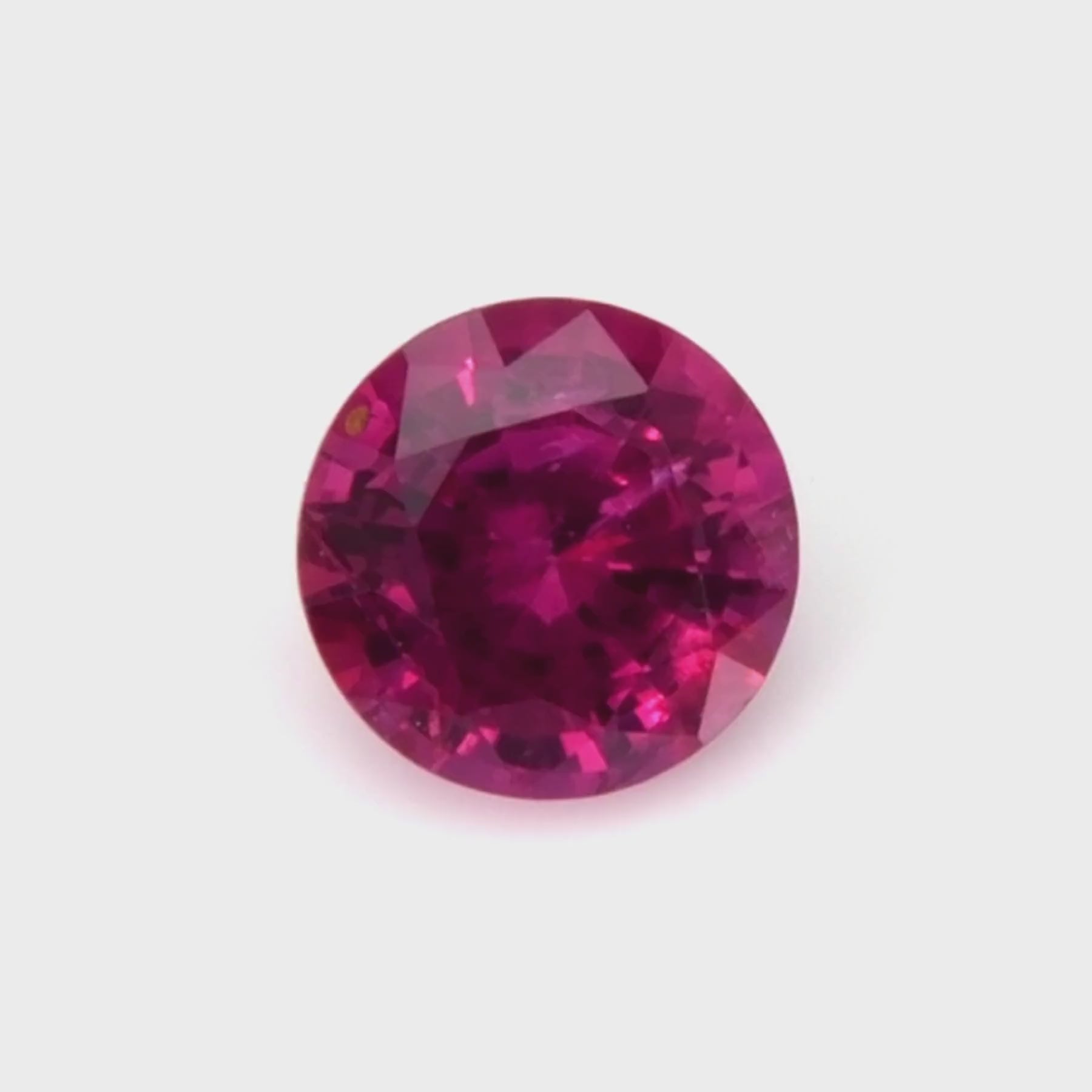 0.52 ct round natural ruby video showing vivid red color and mixed brilliant cut under light