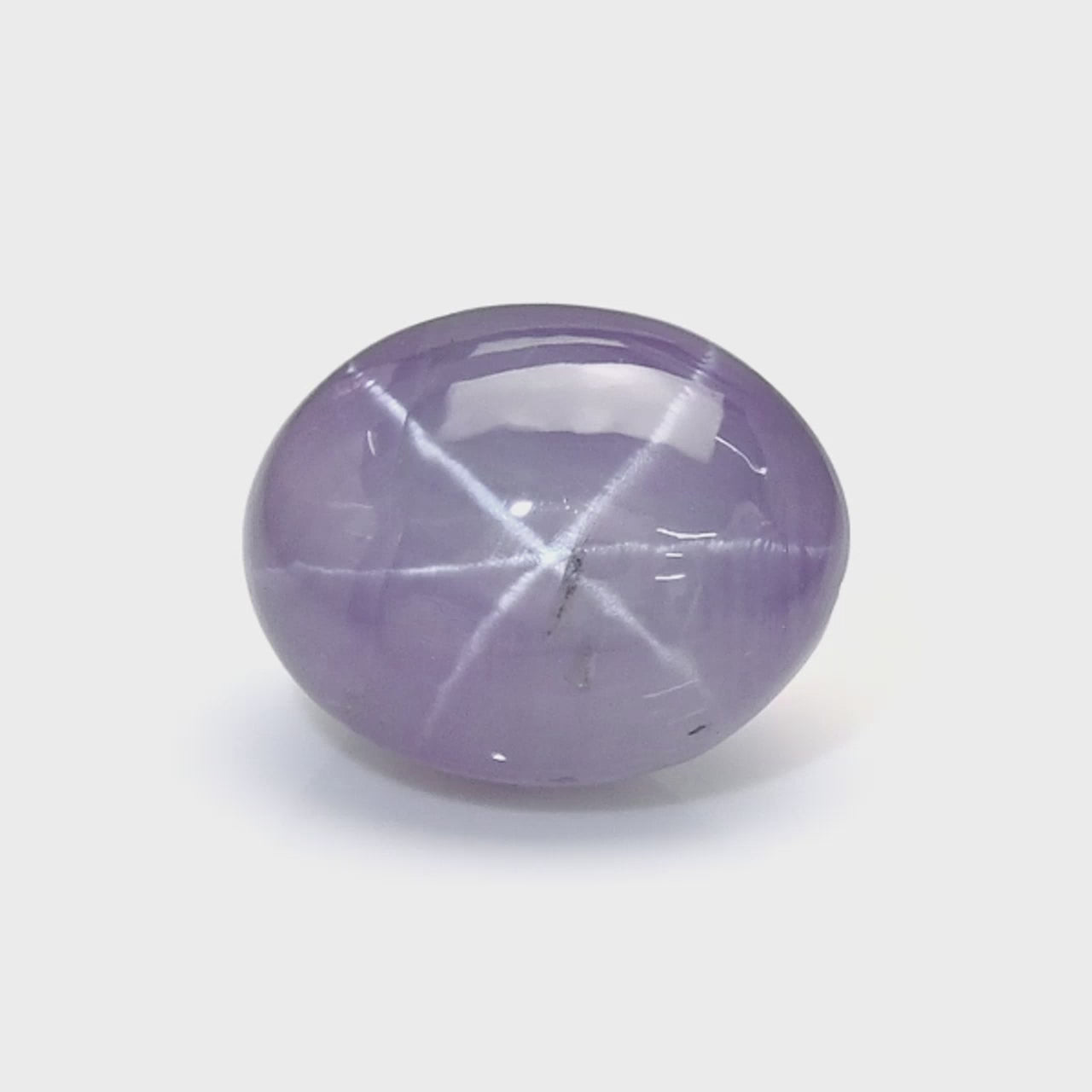 3.40 ct oval violet star sapphire from Ceylon — six-ray asterism demonstrated under directional light